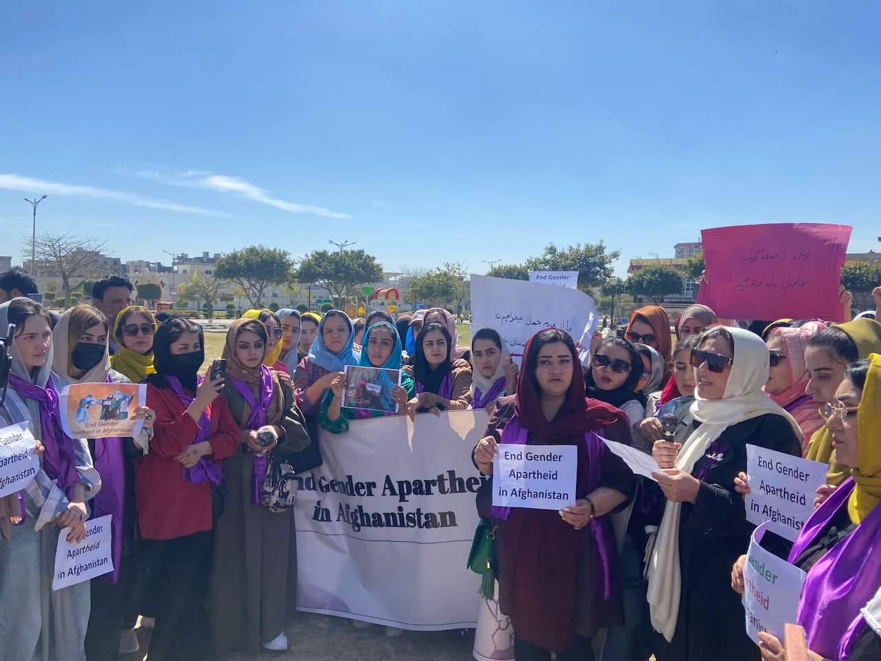 A group of women protesting for rights holding banners outside