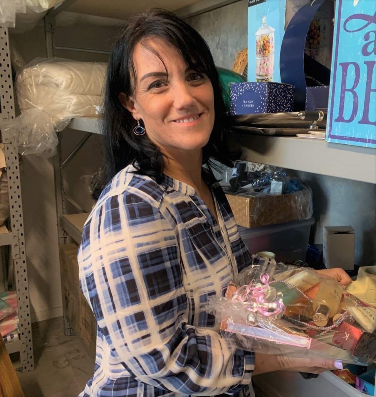 Manuela holding a gift basket of donated goods