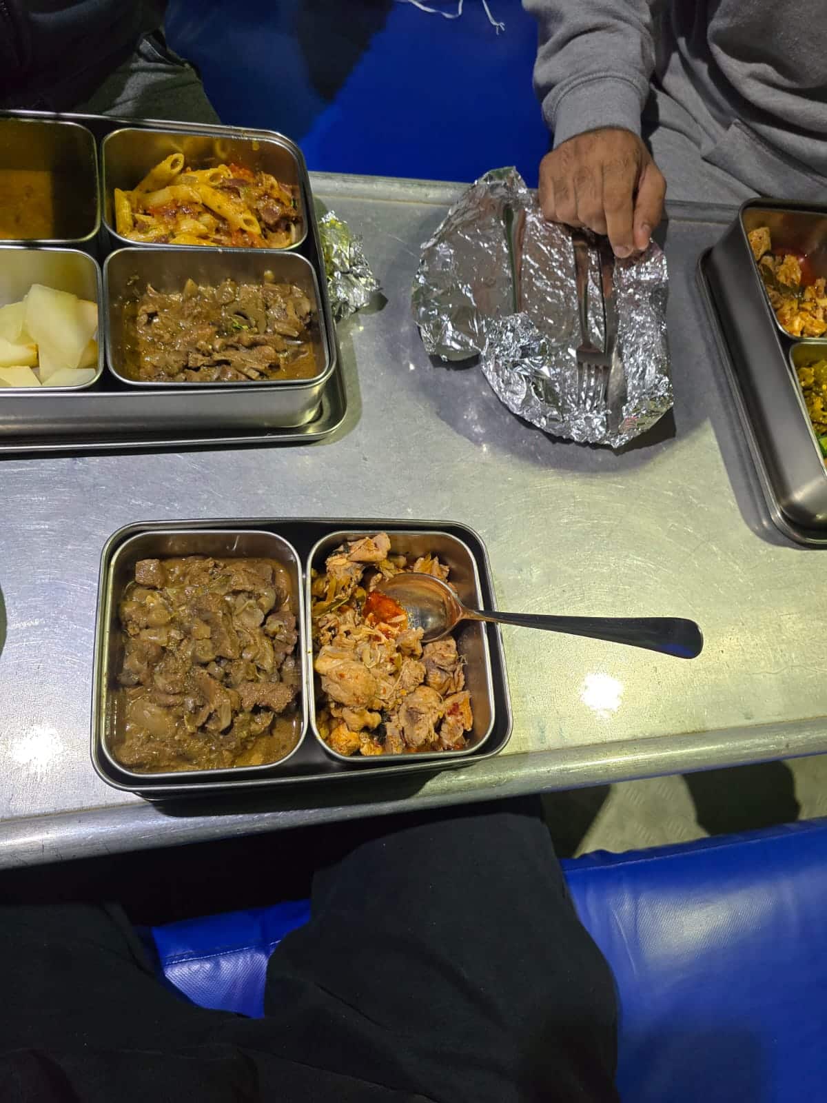 A selection of food in metal dishes on a table.