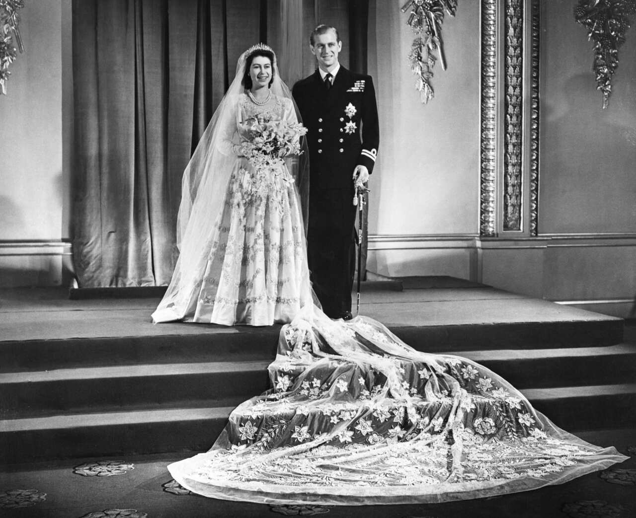 Queen Elizabeth II  in a wedding dress with embroidered stars.