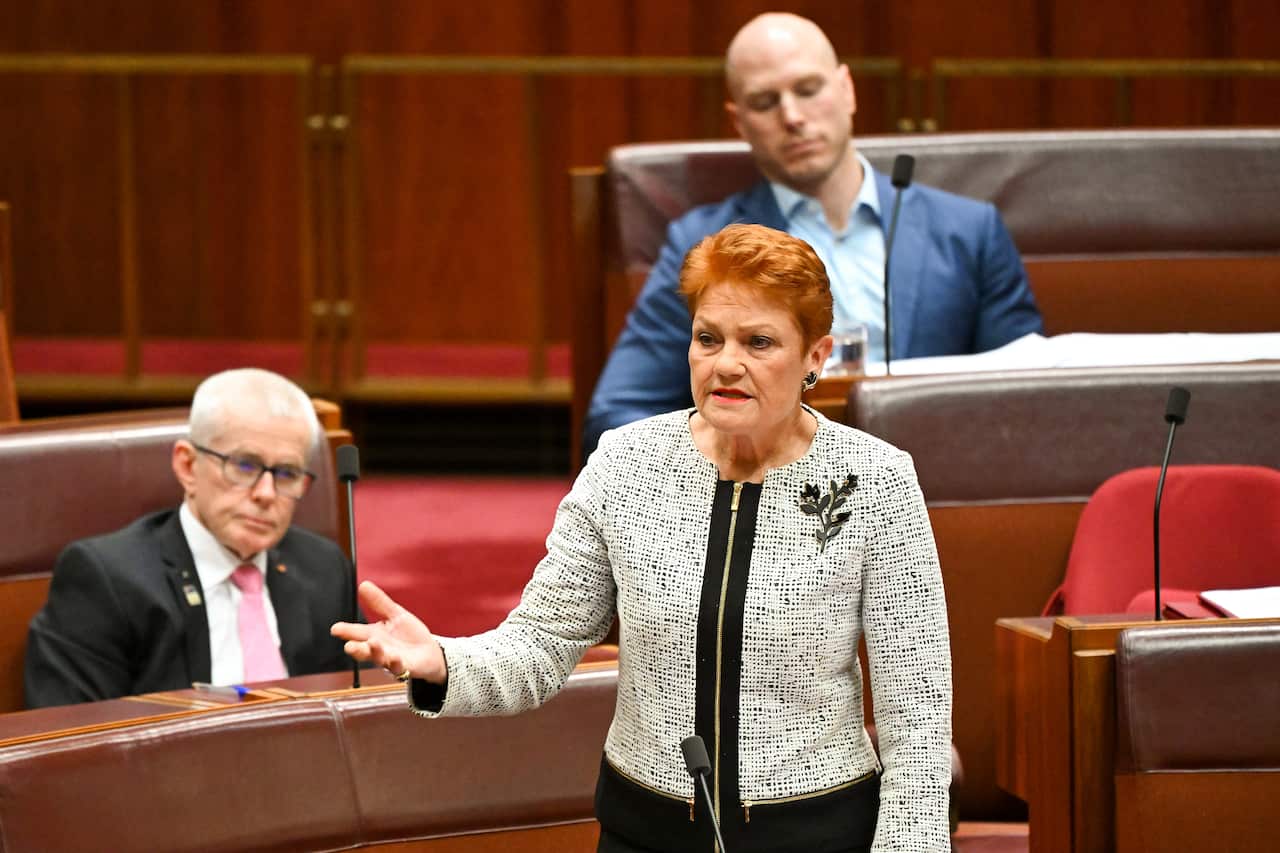 Red-headed woman in jacket speaks.