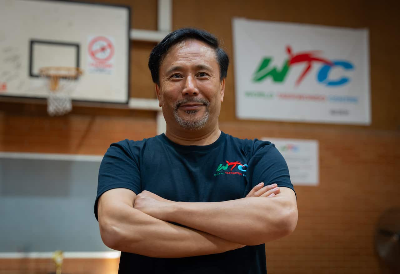 A man posing for a photo with his arms folded.