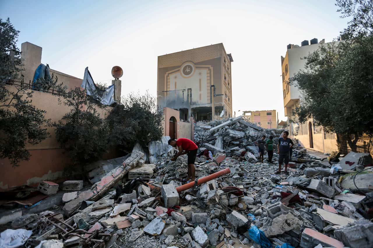 People searching through the rubble of destroyed buildings.