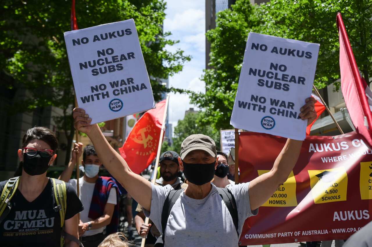 People hold up signs and banners