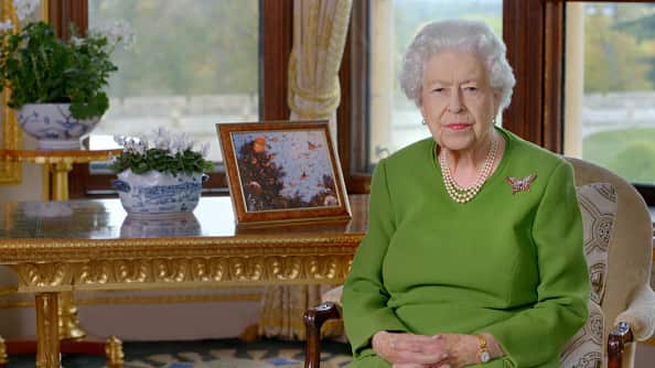 Queen Elizabeth sits on a chair next to a table to give a video address to the COP climate conference in Glasgow in November, 2021.