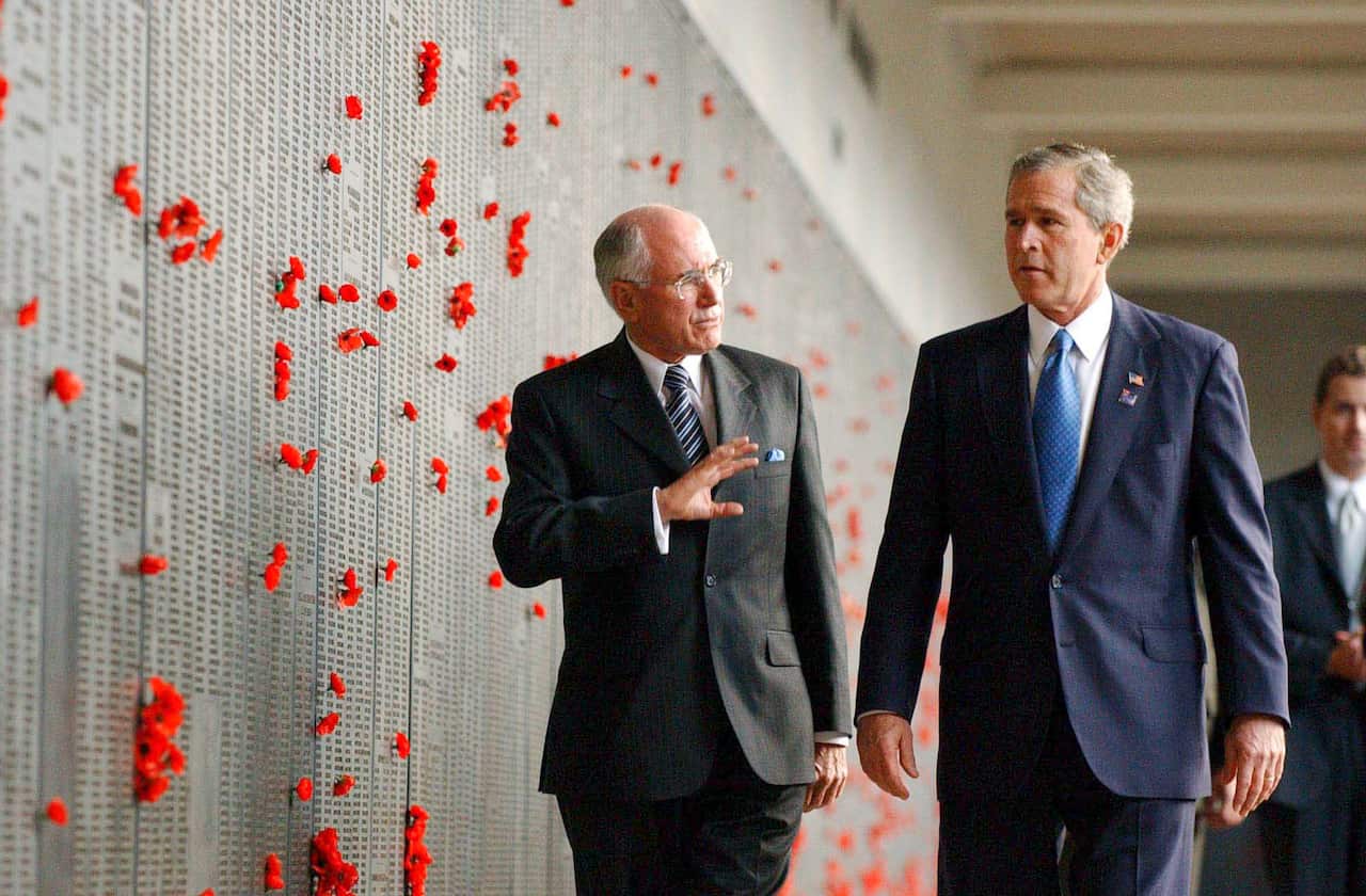 George Bush and John Howard talk while walking side by side at the War Memorial.