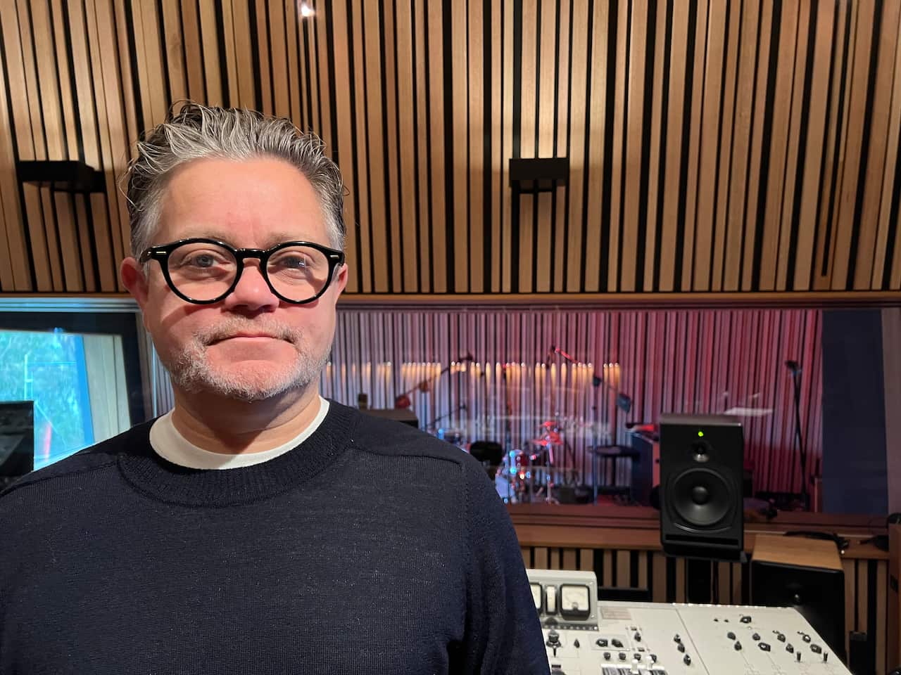 A man wearing glasses pose for a photo