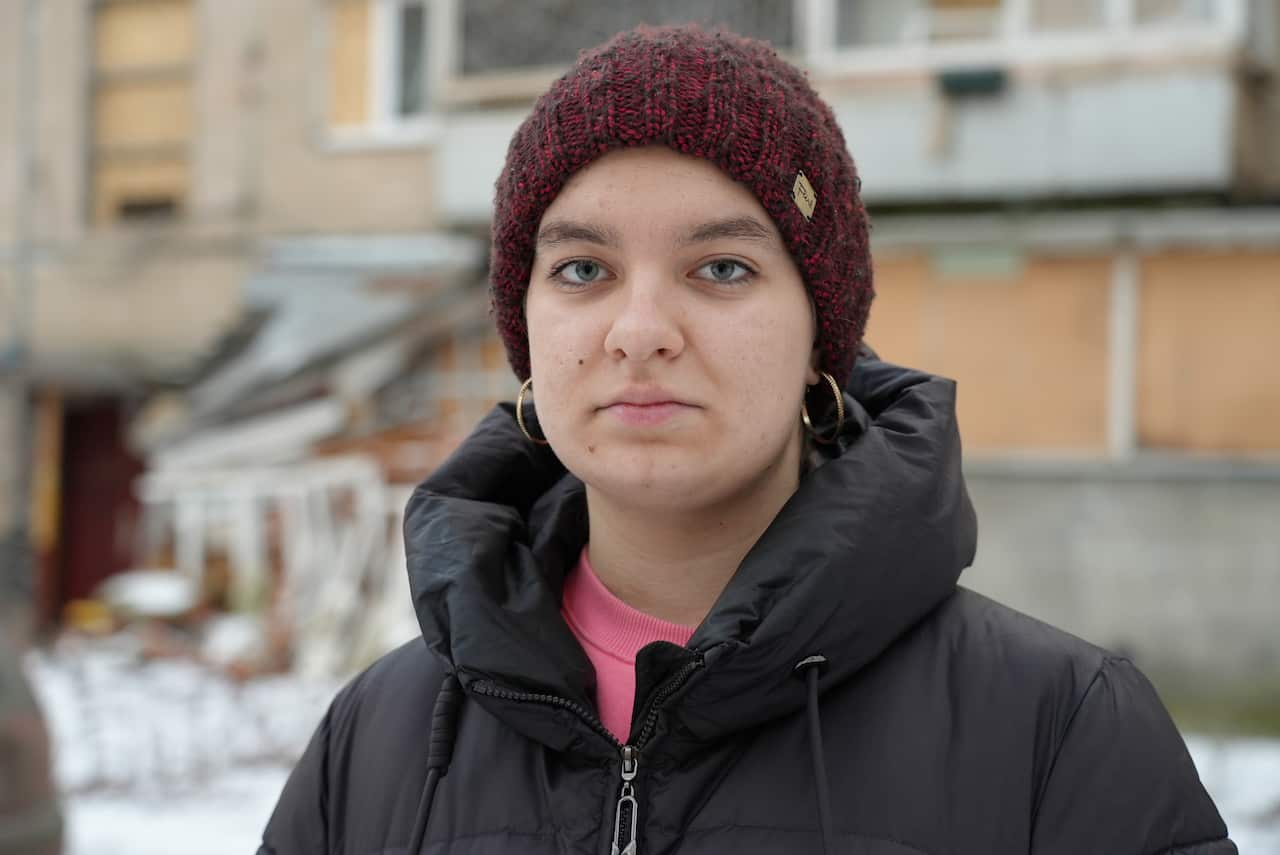 A teenage girl wearing a beanie outside.