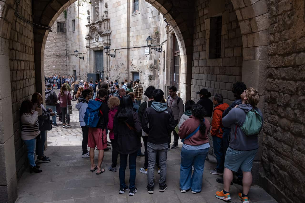 People stand in the archway of an old stone building 