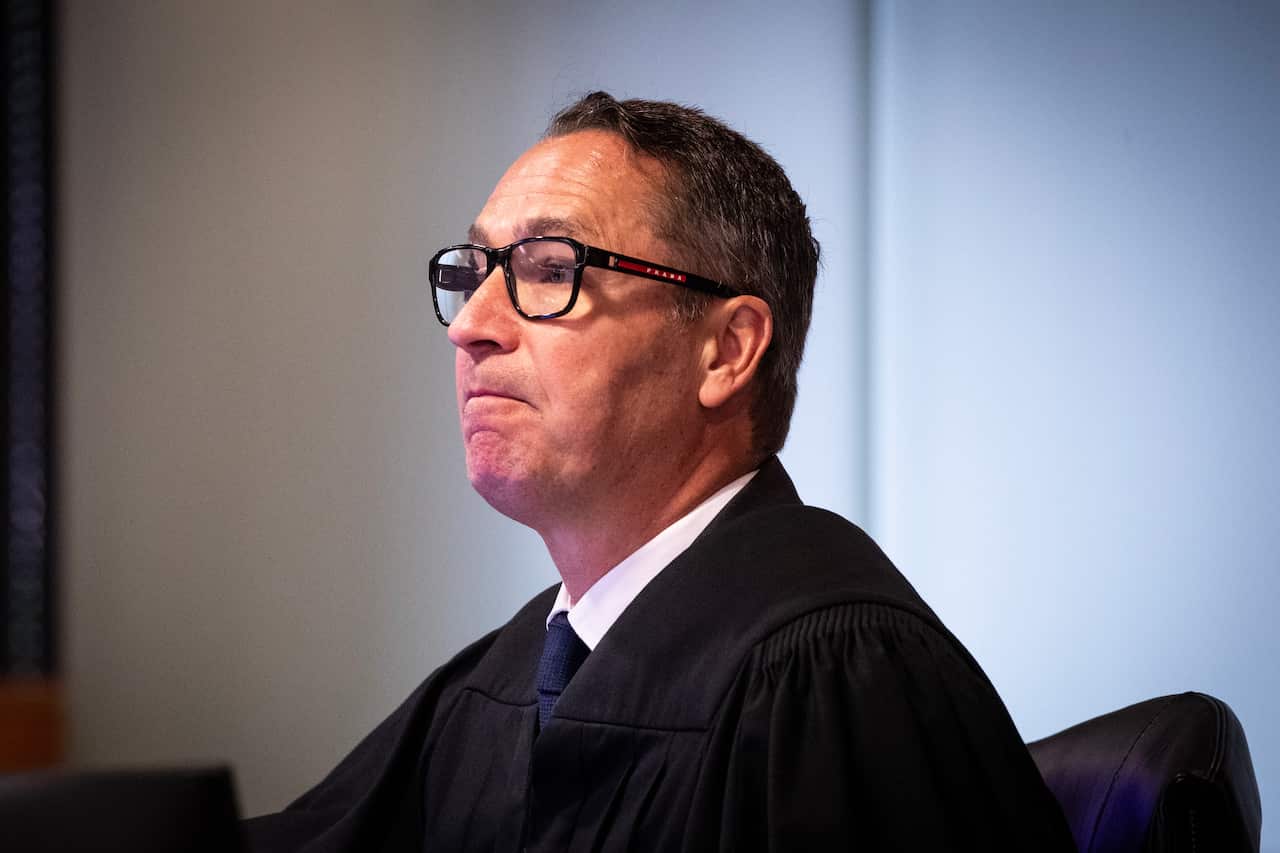 A man wearing glasses and judge's robes.