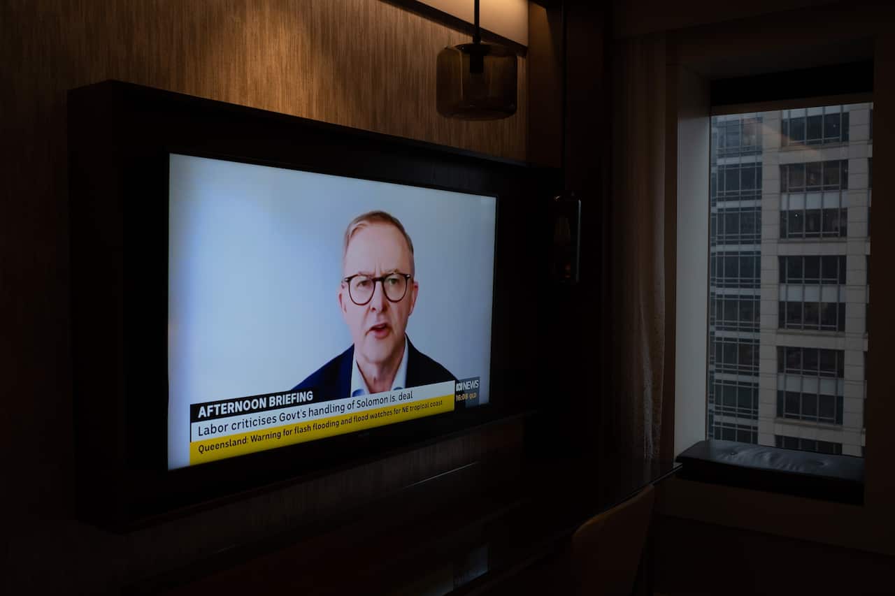 Opposition leader Anthony Albanese is seen on a TV screen as he conducts an interview via video link after testing positive for COVID-19.