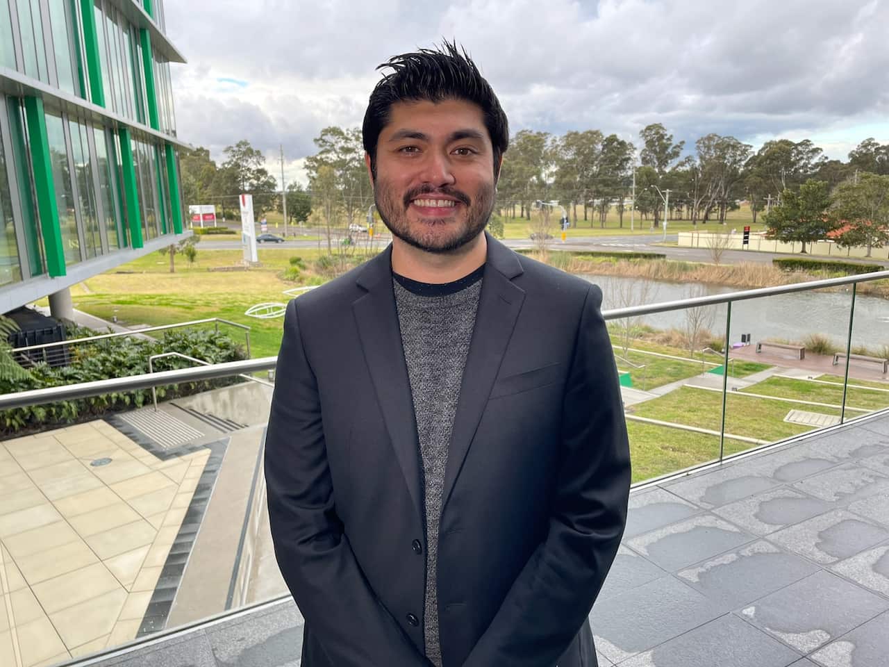 Daniel Angus smiling at the camera in an outdoor setting.