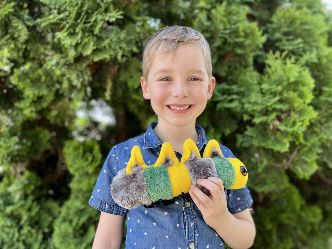 Young boy carries stuffed toy. 