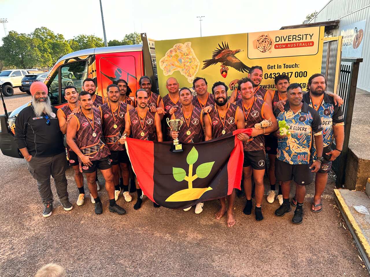 A group of people standing outside a truck. 