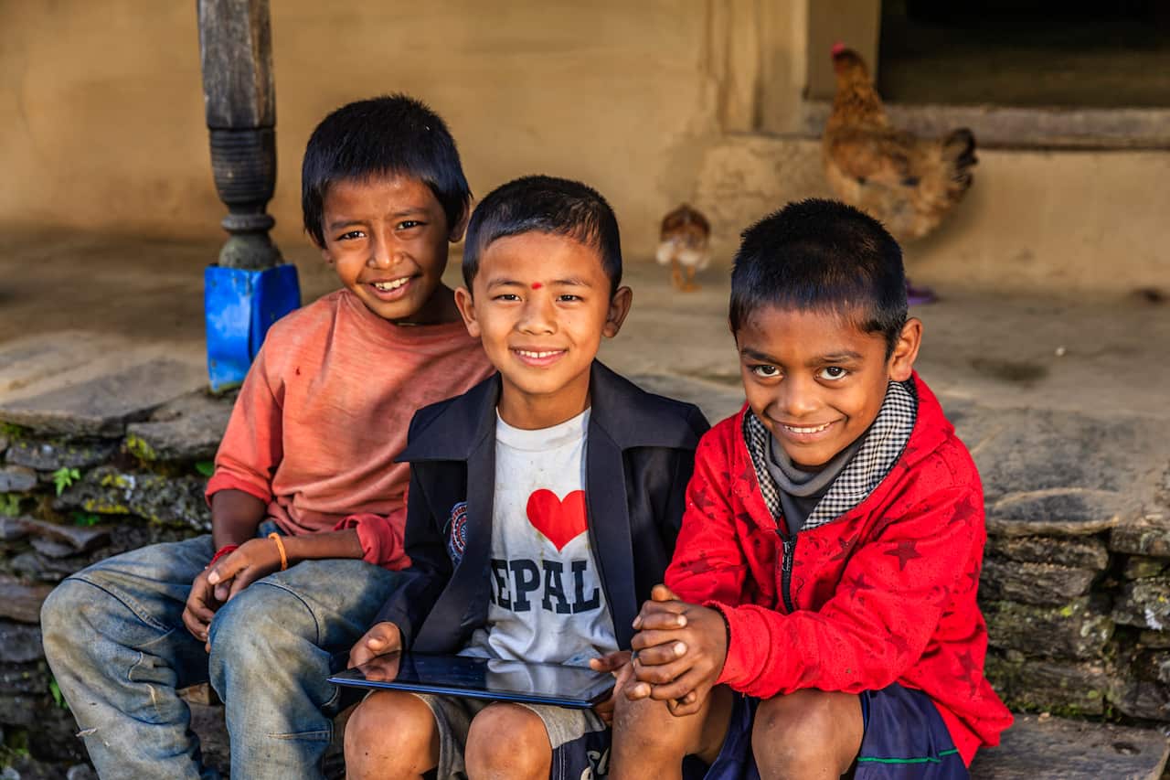 Nepali children using digital tablet near Annapurna Range