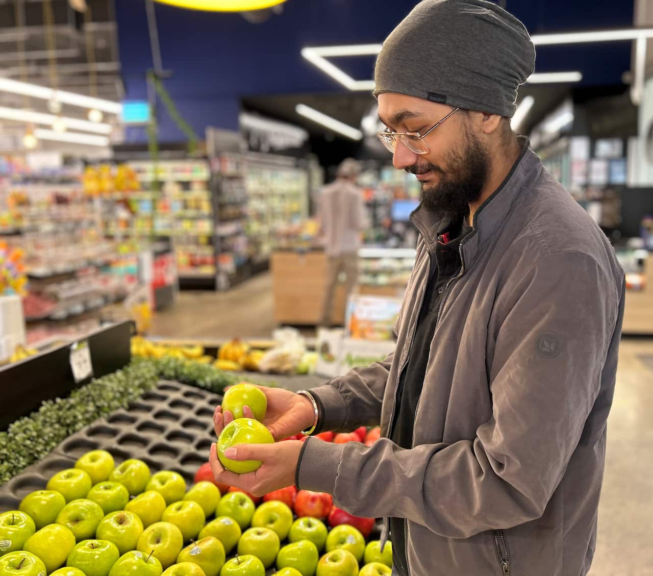 Naunhial packing fruit into a display case.