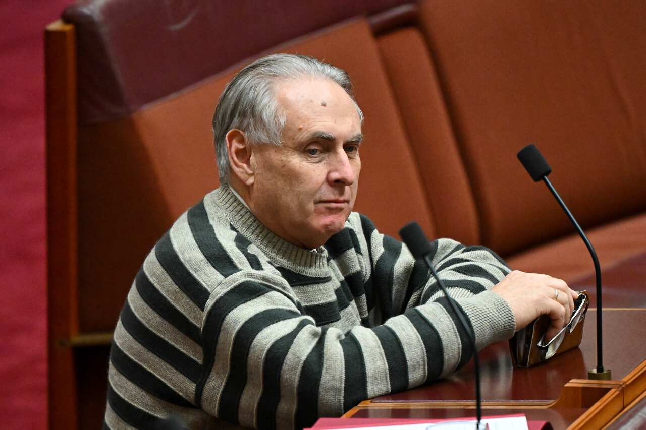 Don Farell, wearing a striped jumper, sits in the Senate