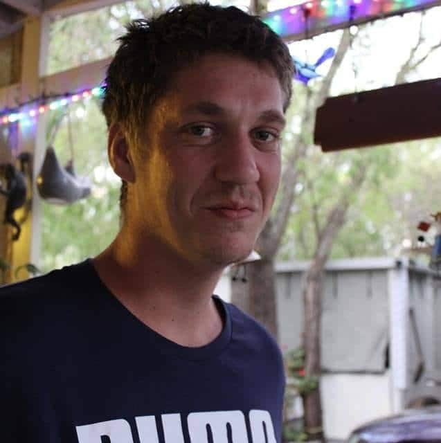 A young man wearing a T-shirt, looking at the camera