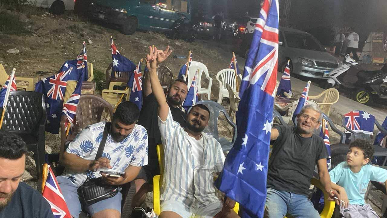 Men with Australian flags sitting on chairs