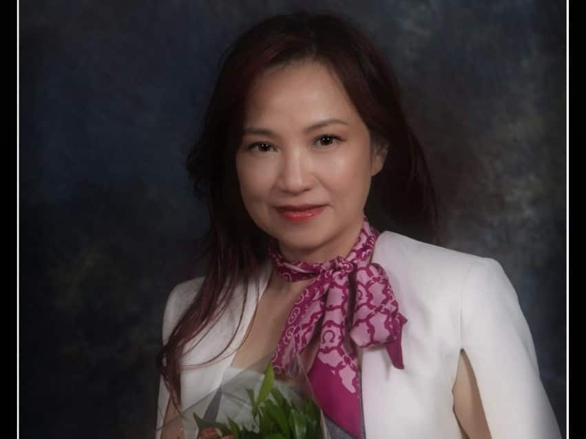 Woman wearing white jacket and purple scarf