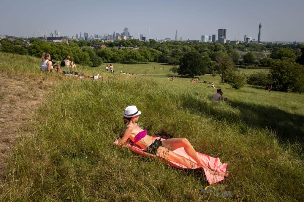 People spend time on Primrose Hill in London during a brief heatwave.