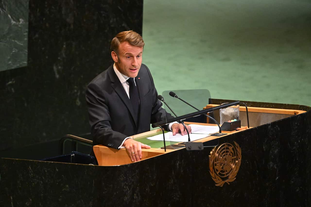 Emmanuel Macron delivers a speech at a podium with a United Nations logo.