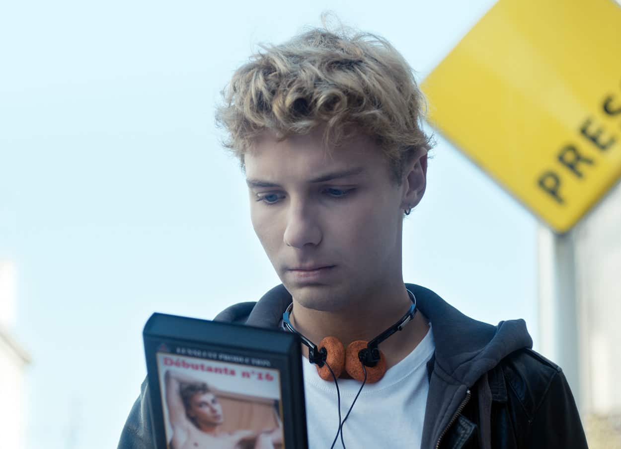 A young man looks pensively at the case of video. 