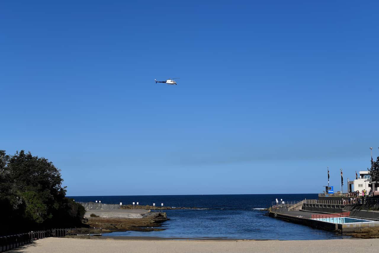 A police helicopter patrolling a beach.