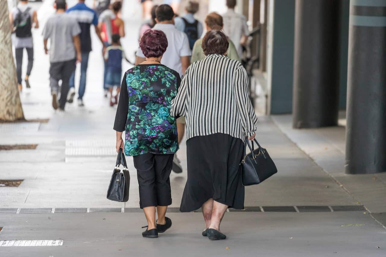 A view from behind of two women walking down an urban street