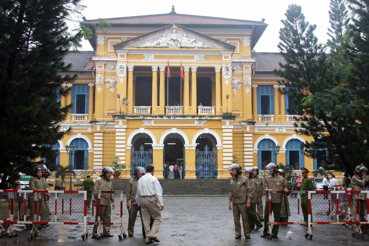 Policemen stand guard in front of Ho Chi