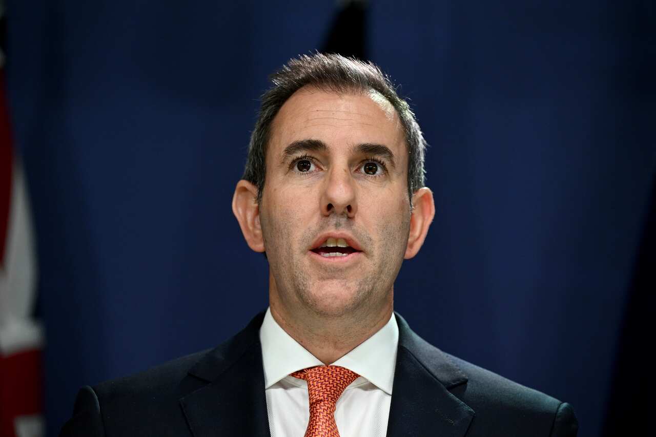 A man wearing a suit and tie is speaking.