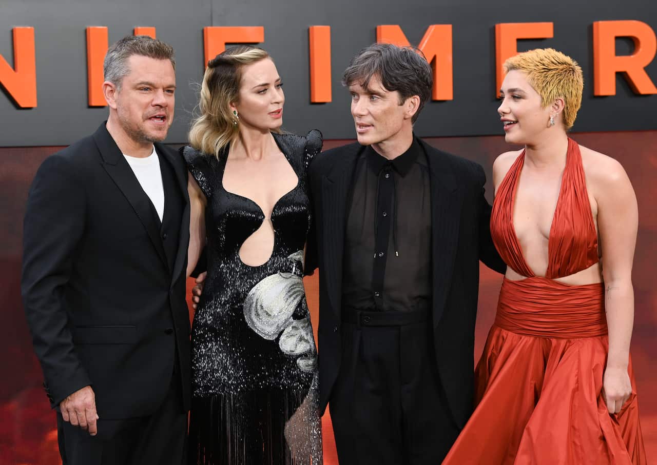 Actors Matt Damon, Emily Blunt, Cillian Murphy and Florence Pugh at the red carpet, in front of a sign that reads Oppenheimer. 