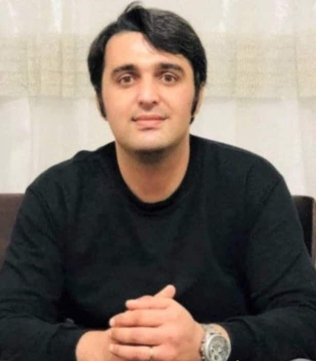 A man in a black jumper sitting at a table.