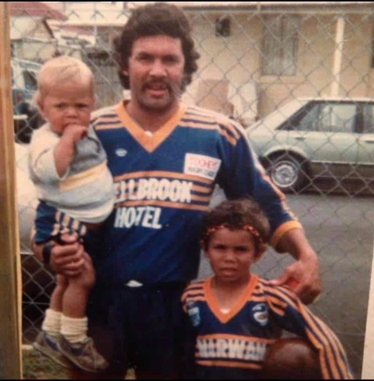 Dennis as a child standing with his father holding football