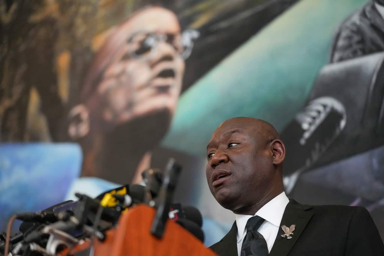A man standing at a lectern and speaking in front of microphones.