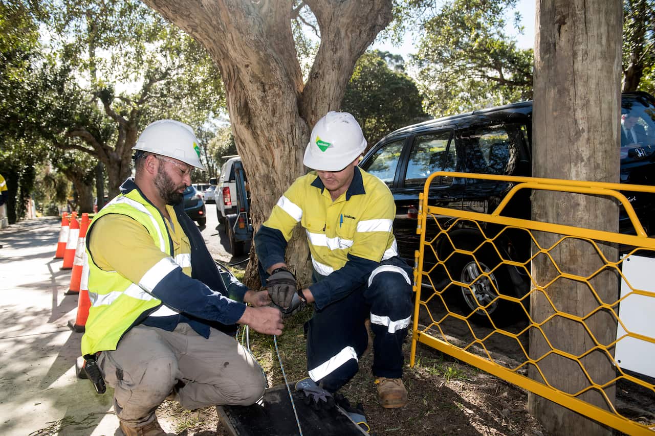 Two workmen laying out cable.