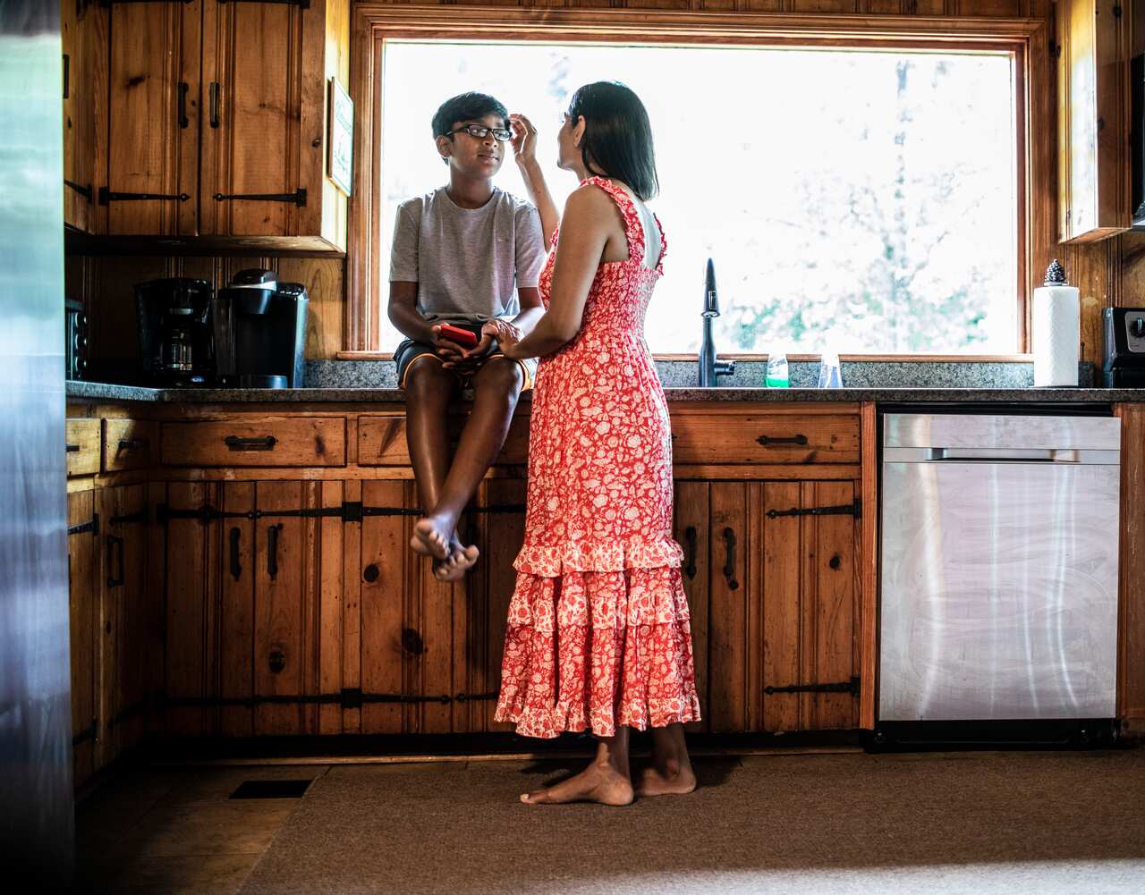Mother comforting son at home