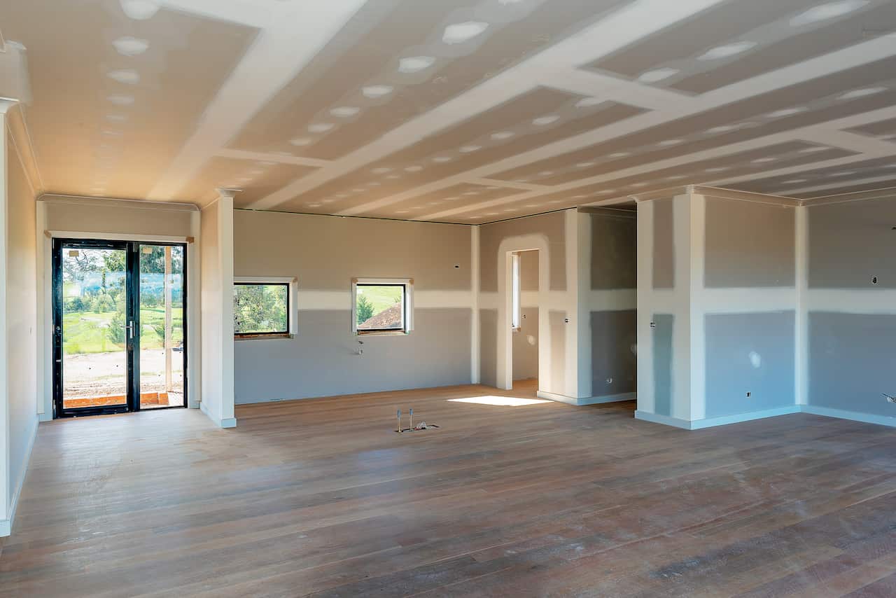 The inside of an empty house, with unfinished walls and ceiling.