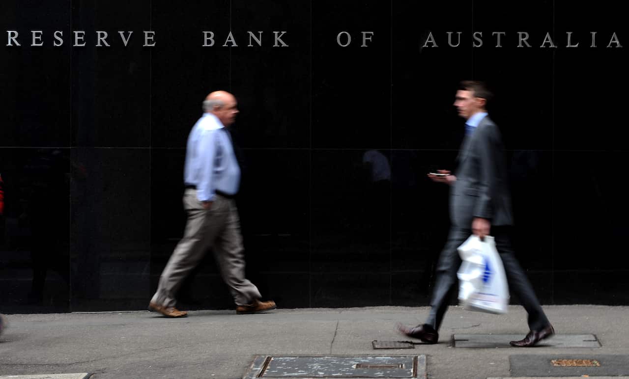 People are seen walking past the Reserve Bank of Australia headquarters in Sydney