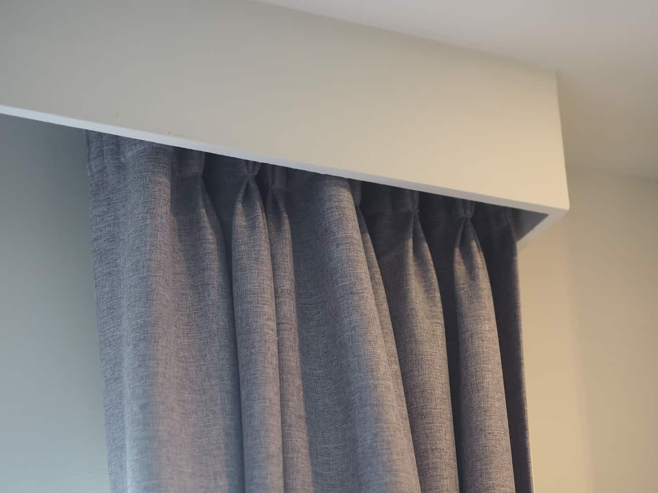 Curtains in a wooden curtain rail box.