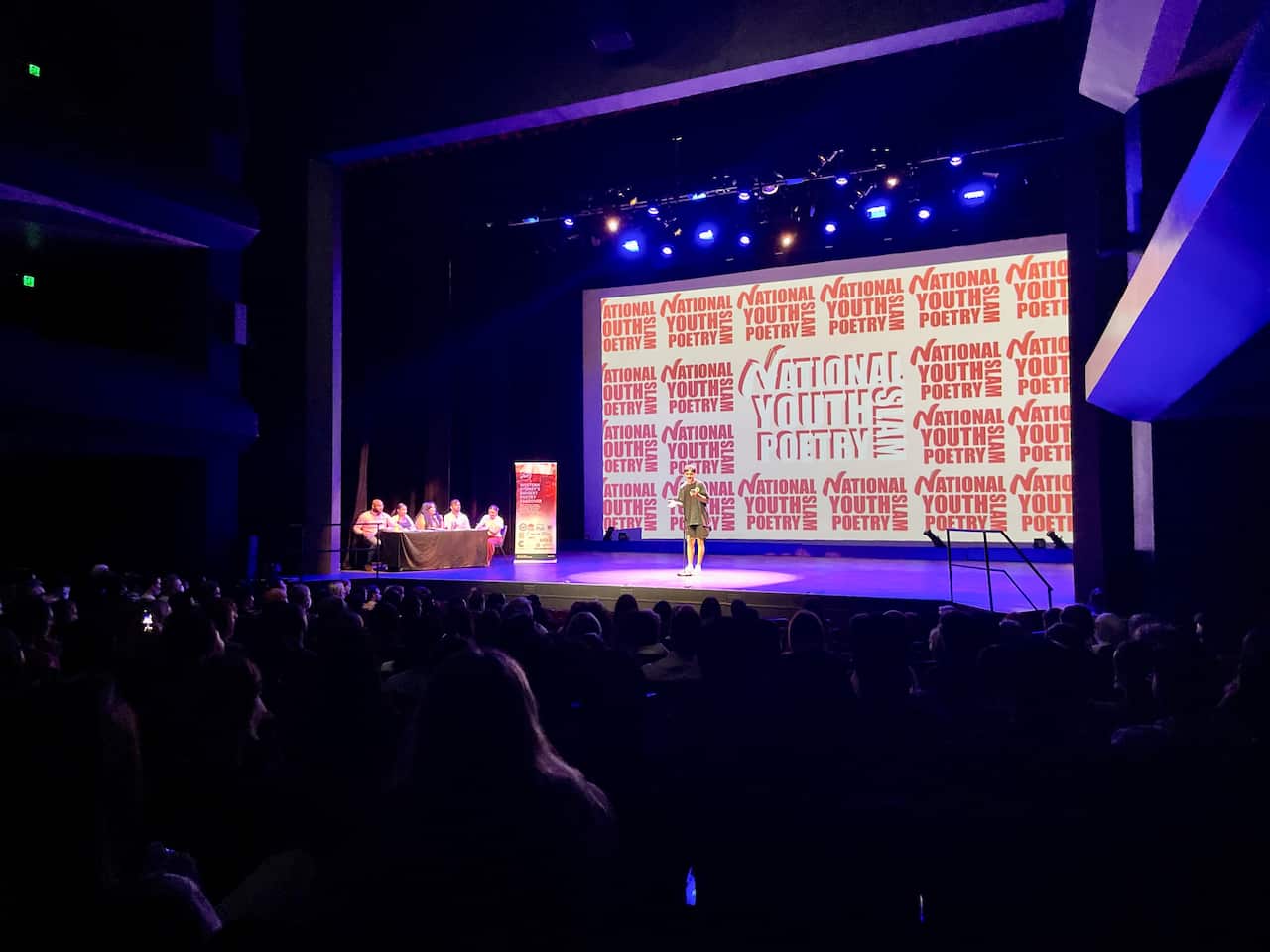 Man stands with a spotlight on a stage.