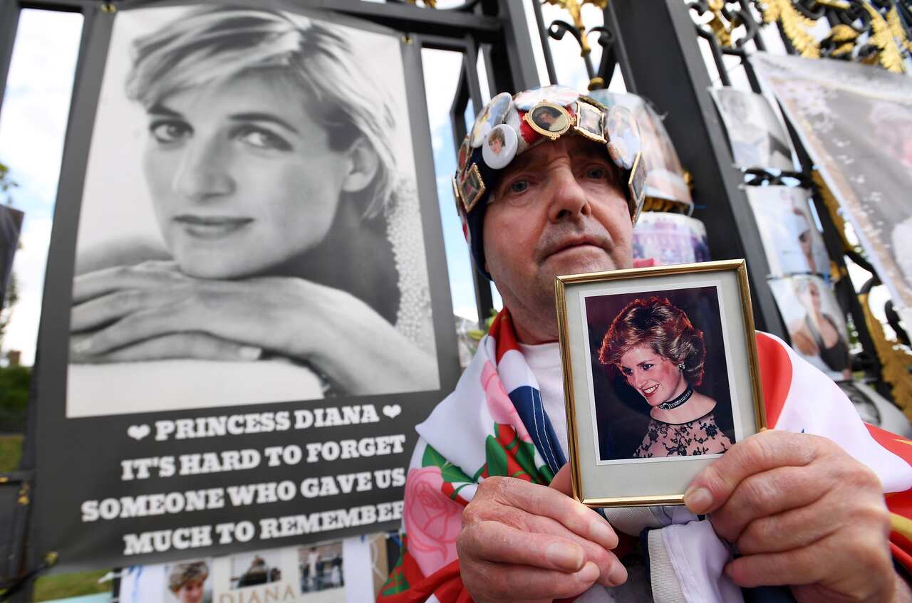 Royal well-wisher John Loughrey holds a photograph of Princess Diana outside Kensington Palace, the former home of Princess Diana in London on 31 August 2022.