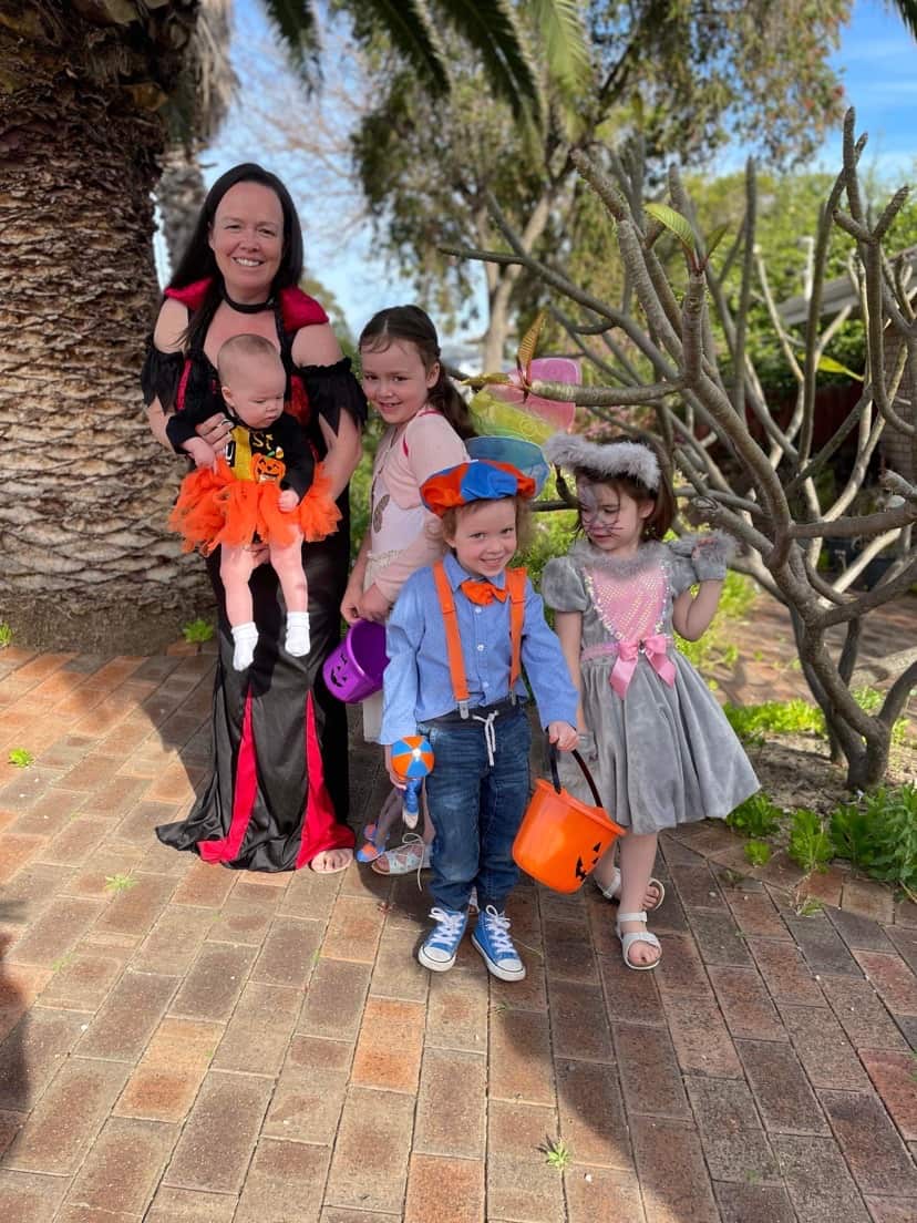 A mother and four children dressed in costumes for Halloween.