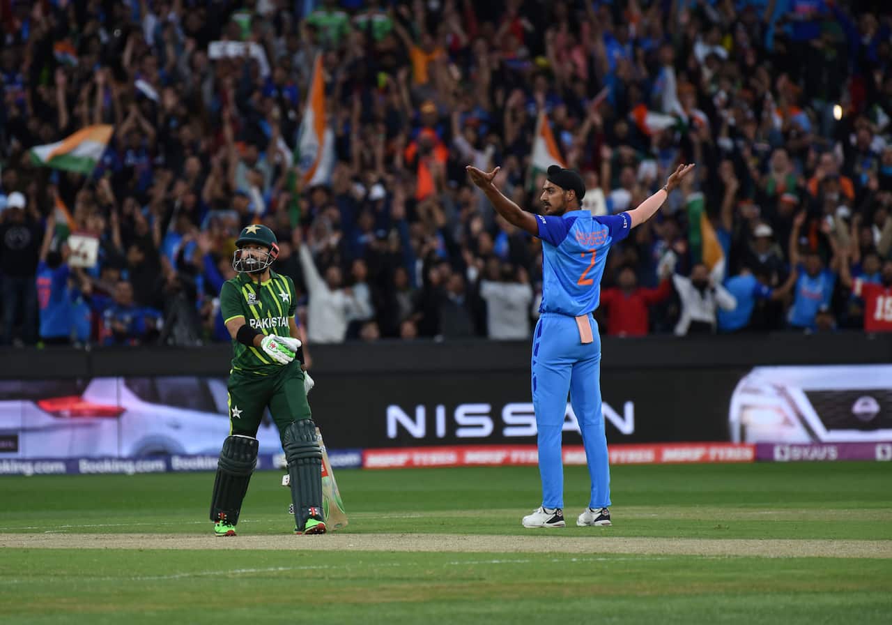 An Indian bowler holds up his arms in front of a Pakistan batsman at the Melbourne Cricket Ground 