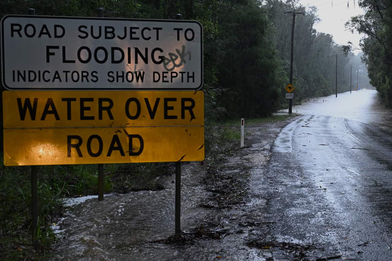 A sign saying 'Water over road' after flooding.