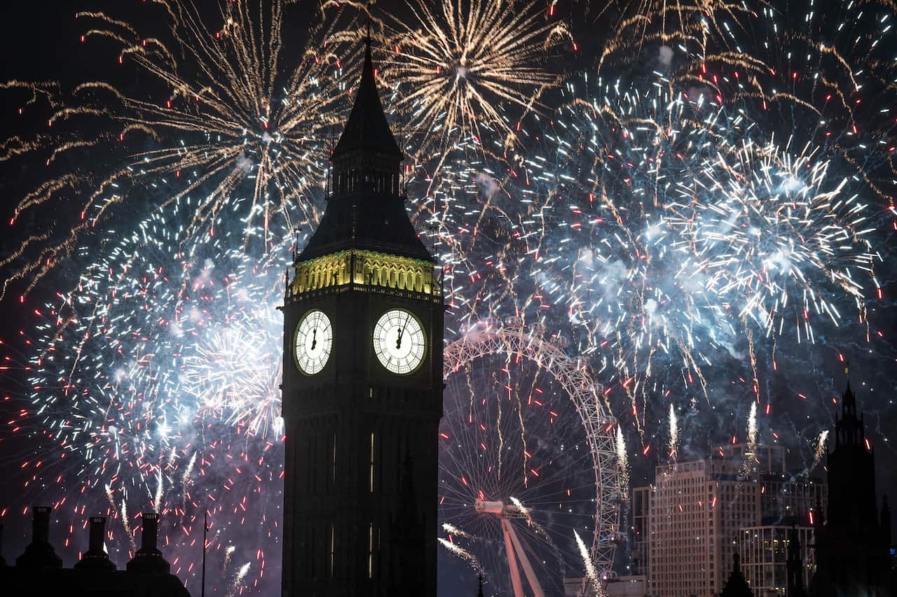 Fireworks going off in London near Big Ben and the London Eye