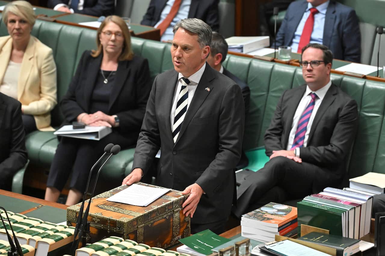 A man speaks at a microphone.