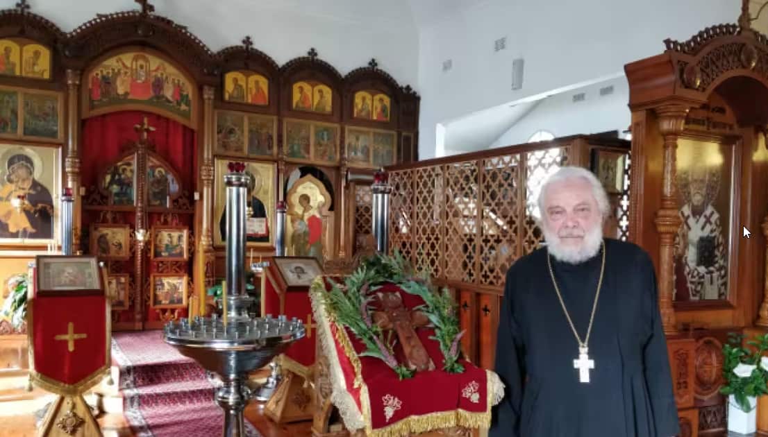 The priest is standing in the church.