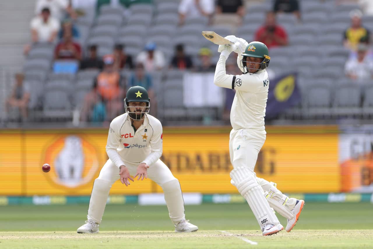 A cricketer swings a bat during a game