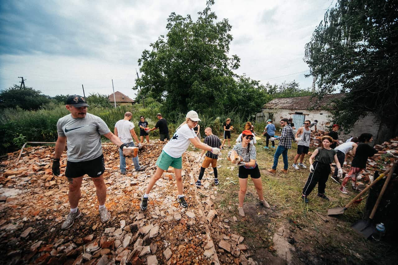 Volunteers help to remove debris from damaged buildings in Ukraine.